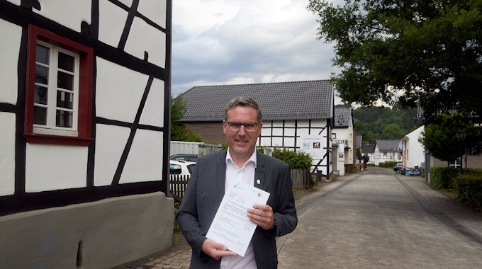 Nettersheims Bürgermeister Norbert Crump präsentiert den Förderbescheid.