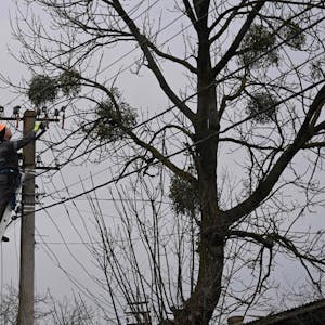 Ein Arbeiter repariert nach einem russischen Angriff eine Stromleitung in einem Dorf in der Nähe der ukrainischen Stadt Lwiw.
