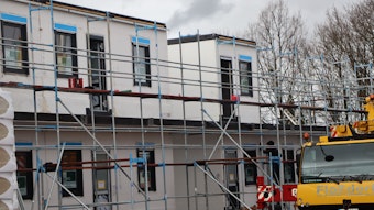 Das Foto zeigt den Fortgang der Bauarbeiten in Erftstadt: Wie Legosteine werden die Wohnmodule nebeneinander und aufeinander gesetzt. Dann beginnt auch direkt der Innenausbau.