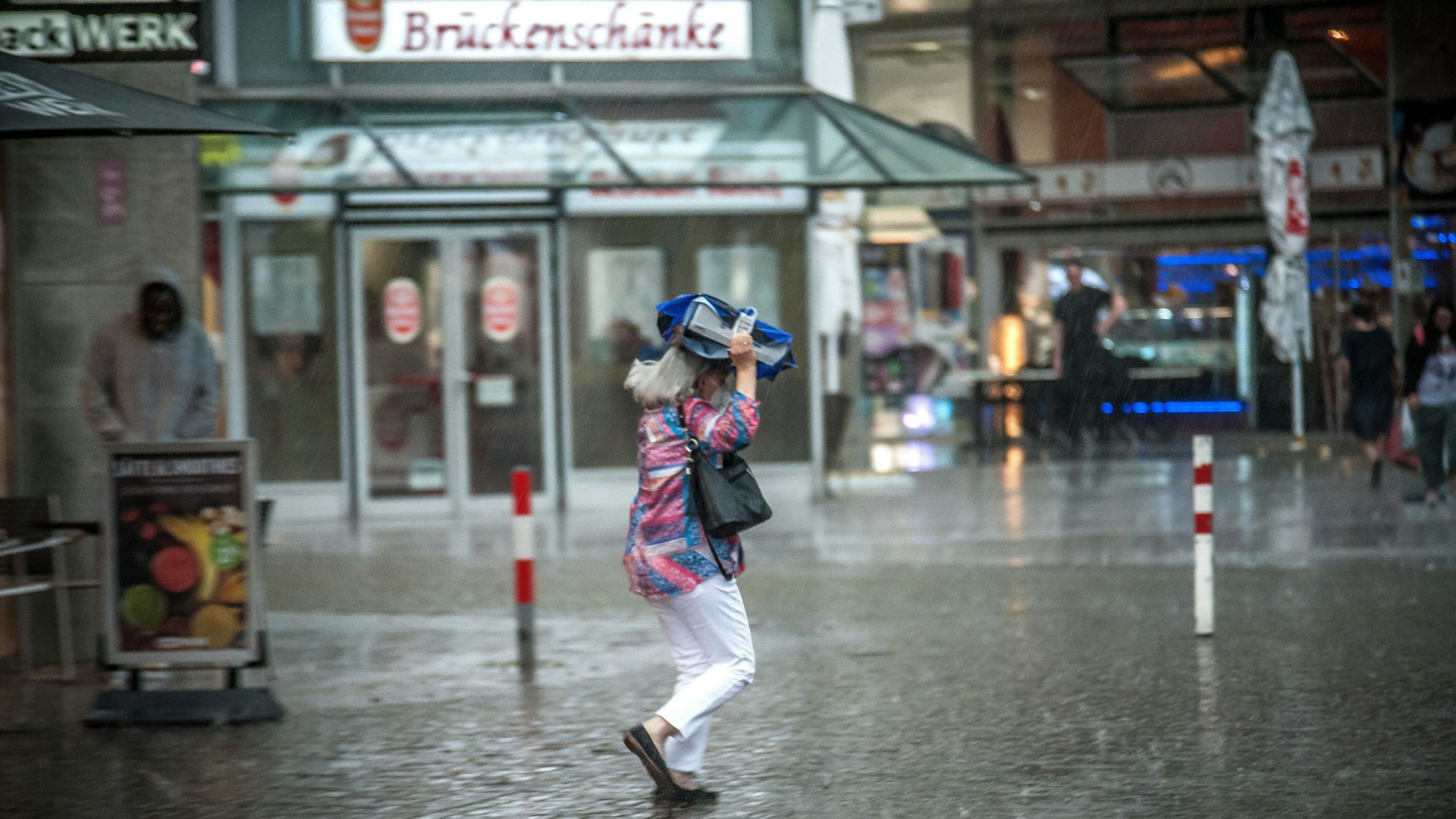 Eine Frau in starkem Regen in Wiesdorf