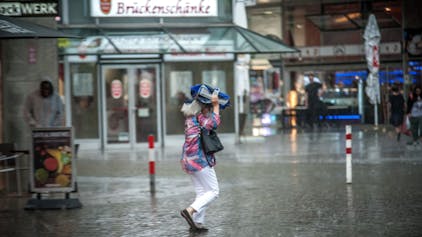 Eine Frau in starkem Regen in Wiesdorf