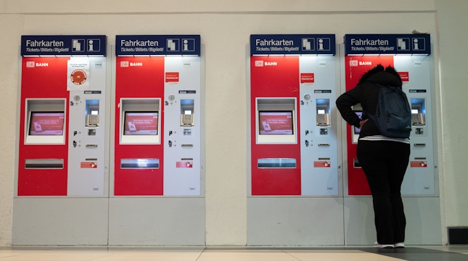 Eine Frau steht im Hauptbahnhof an einem Fahrkartenautomaten.