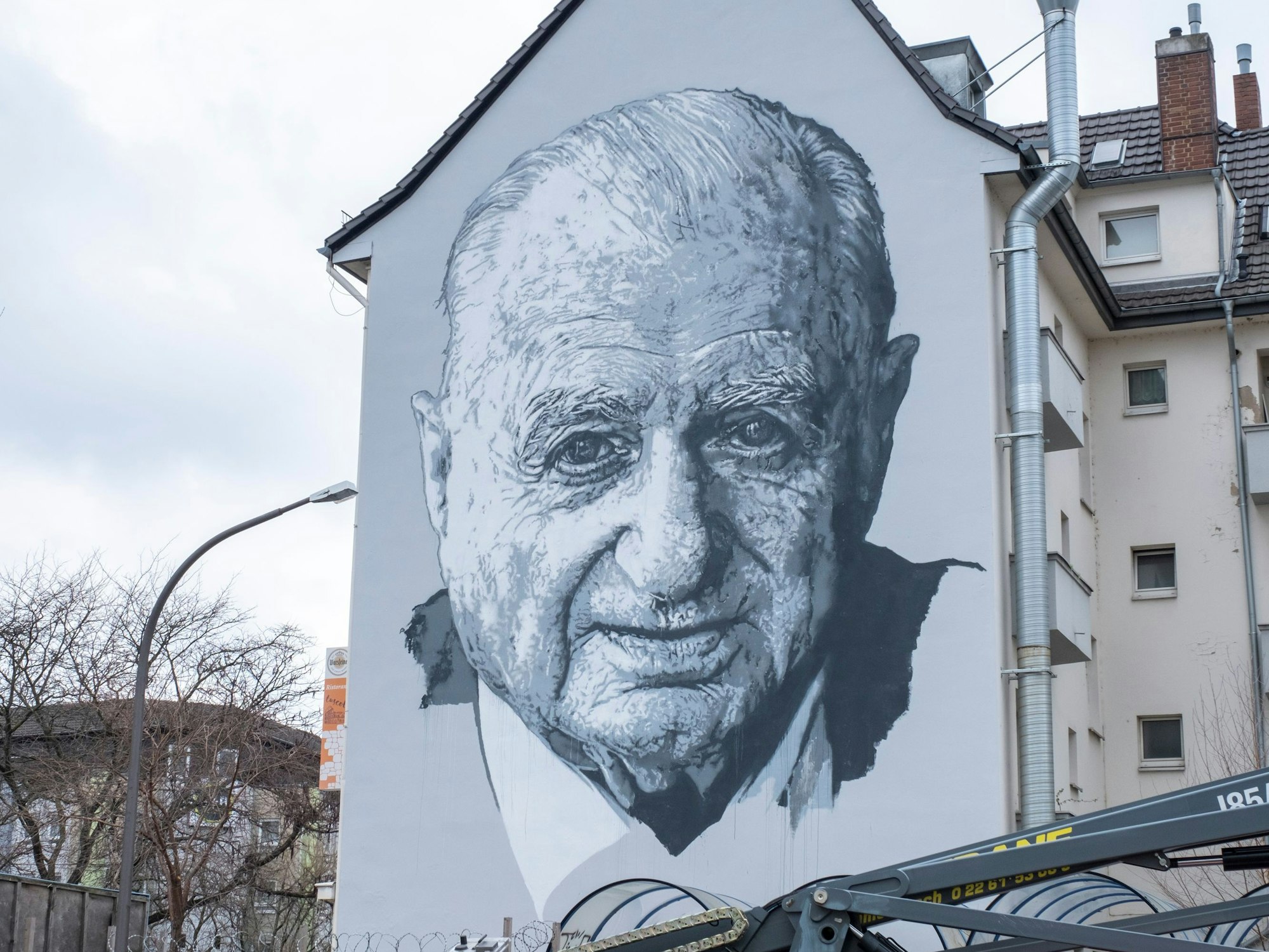 Künstler Hendrik Beikirch hat ein Porträt von Hans Riegel an eine Hauswand in Bonn gemalt.