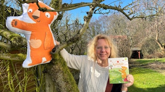 Ein aufblasbarer Apfelbär sitzt im Apfelbaum, Annette Langen mit ihrem Buch