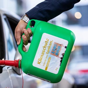 Ein Auto wird mit einem Kanister mit der Aufschrift «Klimaschutz könnte man Tanken - E-Fules for Future» an einer Tankstelle mit E-Fuel betankt.