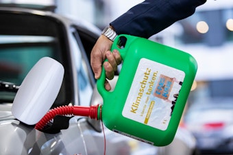 Ein Auto wird mit einem Kanister mit der Aufschrift «Klimaschutz könnte man Tanken - E-Fules for Future» an einer Tankstelle mit E-Fuel betankt.