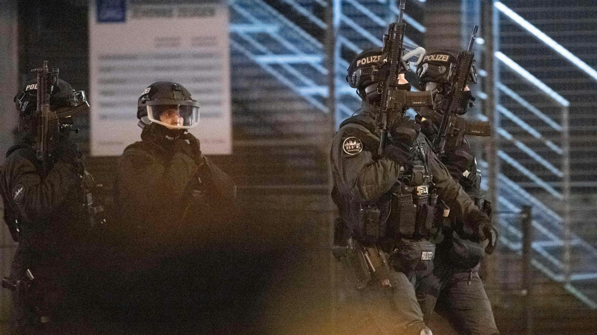 Bewaffnete Polizisten patrouillieren vor dem Gebäude der Zeugen Jehovas, in der mehrere Menschen bei einer Schießerei in Hamburg getötet wurden