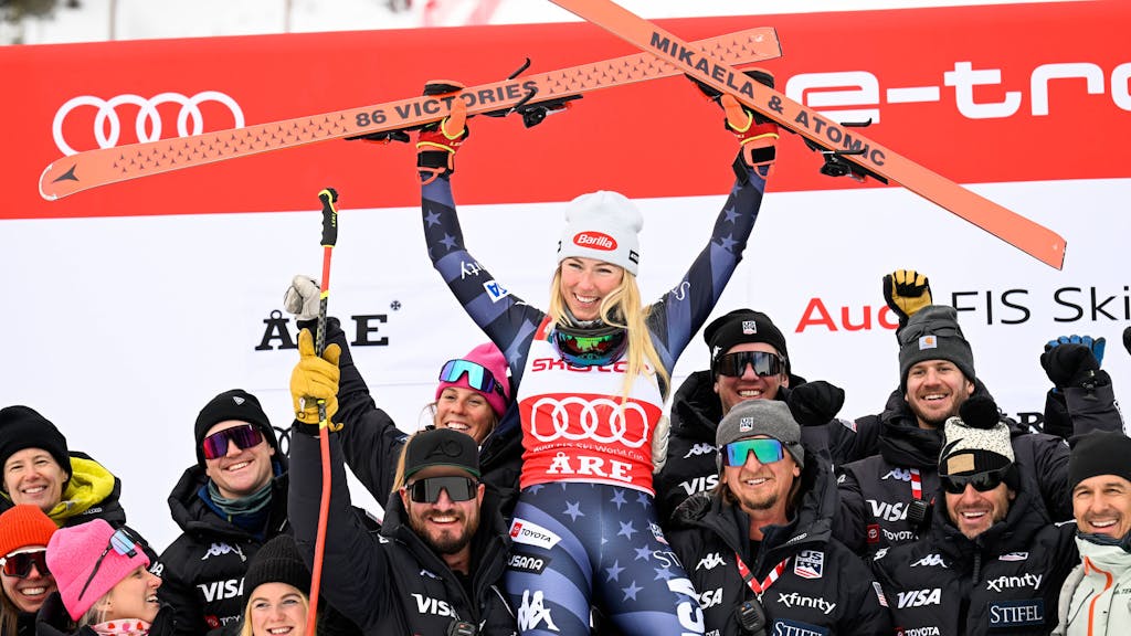 Mikaela Shiffrin jubelt und hält ihre Skier in die Höhe.