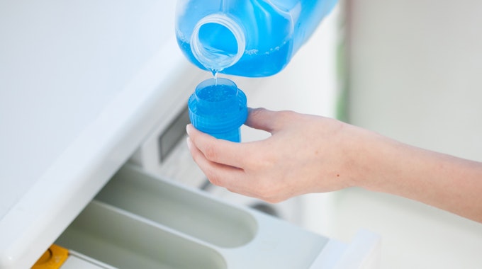 Stiftung Warentest hat 20 Waschmittel unter die Lupe genommen. Unser Symbolbild zeigt Flüssigwaschmittel, das in eine Waschmaschine gefüllt wird.