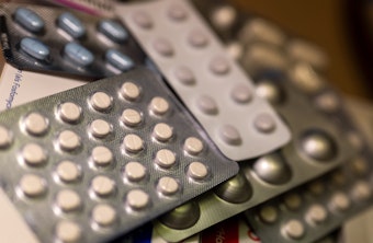 Diverse Medikamentenpackungen liegen auf einem Tisch in einer Apotheke.
