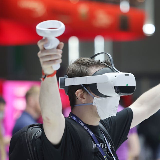 Gamescom 2022: Ein Messebesucher testet mit einer VR Brille (Virtual Reality) ein Computerspiel.