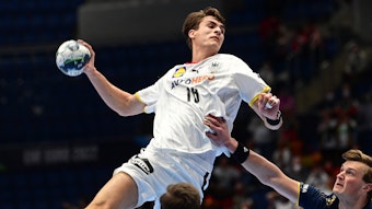 Ein Handballer setzt mit Ball in der Hand zum Sprungwurf an.