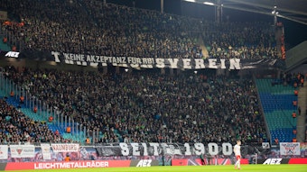 Gladbach-Fans im Gäste-Block der Leipziger Arena bringen ihren Standpunkt zu RB Leipzig zum Ausdruck. Dieses Foto stammt vom 1. Februar 2020. Zu sehen sind riesiger Banner mit Aufschriften.