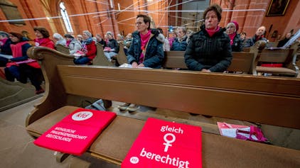 Ein rotes Sitzkissen auf einer Bank im Frankfurter Dom mit der Aufschrift „gleich berechtigt“ und dem Frauen-Symbol weist auf die Forderung des kirchlichen Reformprozesses „Synodaler Weg“ hin, die Weiheämter in der katholischen Kirche für Frauen zu öffnen.