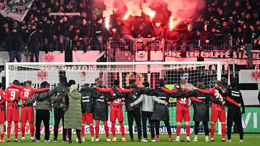 Die Spieler von Eintracht Frankfurt jubeln mit ihren Fans in der Kurve.