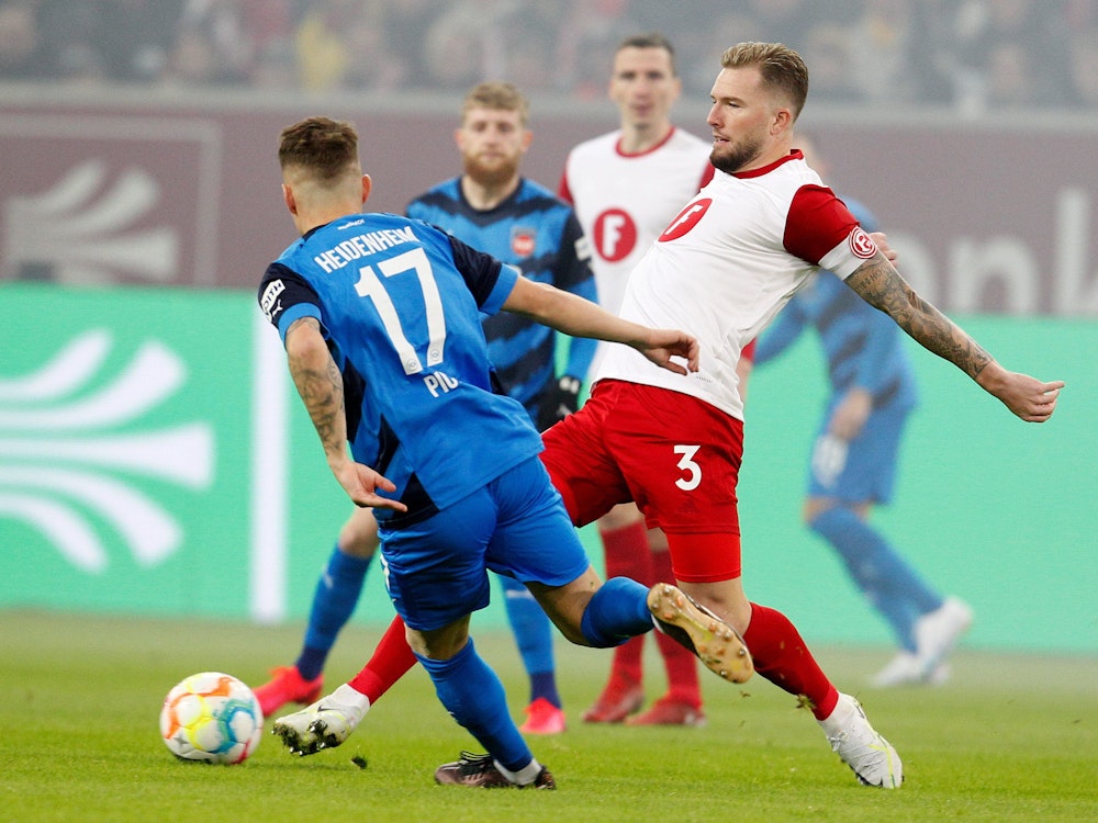 Der Düsseldorfer Andre Hoffmann (r) und der Heidenheimer Florian Pick kämpfen um den Ball.