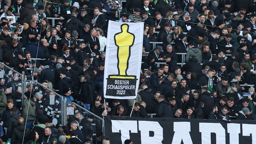 Fans von Borussia Mönchengladbach zeigen ein Banner mit der Aufschrift „Bester Schauspieler 2022“ in Anlehnung an die Oscar-Verleihung beim Bundesliga-Auswärtsspiel bei RB Leipzig am 11. März 2023. Das Banner ist augenscheinlich an Ex-Gladbach-Manager Max Eberl gerichtet, der nach seinem Borussia-Abgang 2022 kritisch gesehen wird. Das Banner ist auf einem Doppelhalter zu sehen.