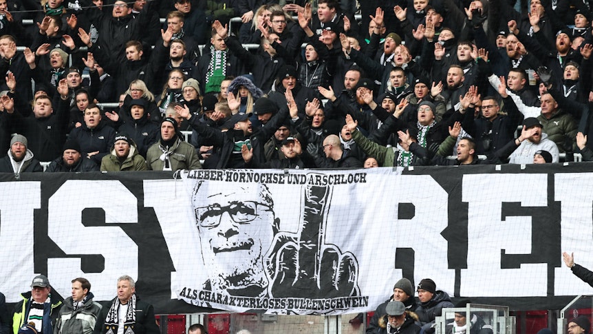 Ein weiteres Banner im Block von Borussia Mönchengladbach zeigt das Konterfei von Max Eberl, einen ausgestreckten Mittelfinger und den Satz „Lieber Hornochse und Arschloch als charakterloses Bullenschwein“. Das Banner war beim Gladbach-Auswärtsspiel bei RB Leipzig am 11. März 2023 zu sehen.