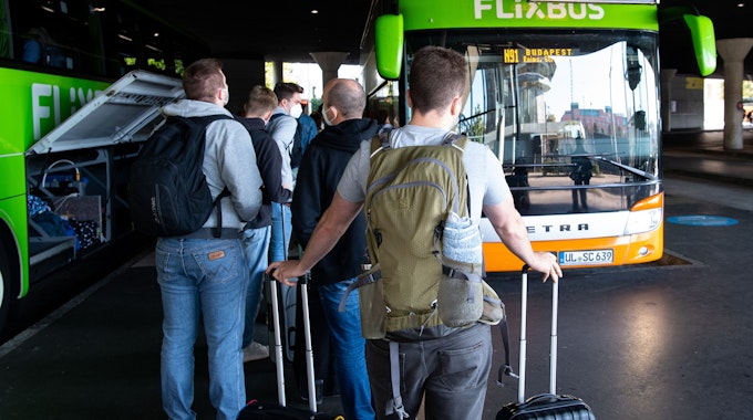 Reisende stehen im Jahr 2021 am Busbahnhof (ZOB) in München an einem Flixbus.