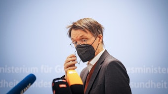 Karl Lauterbach (SPD), Bundesminister für Gesundheit, nimmt zu Beginn eines Pressestatements in seinem Ministerium die FFP2-Maske ab.