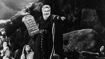 Charlton Heston als Moses hält die Zehn Gebote auf Stein hoch.