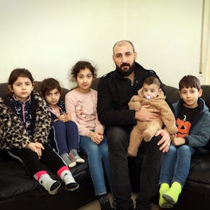 Saad, syrischer Familienvater, und seine fünf Kinder sitzen auf einem Sofa.&nbsp;