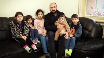 Saad, syrischer Familienvater, und seine fünf Kinder sitzen auf einem Sofa.