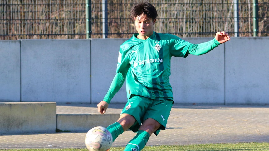 Shio Fukuda, hier am 14. Februar 2023, läuft seit Anfang Februar 2023 für Borussia Mönchengladbach auf und kommt aktuell für die U19 zum Einsatz. Auf dem Foto tritt der Angreifer aus Japan eine Ecke im grünen Auswärts-Trikot von Gladbach.