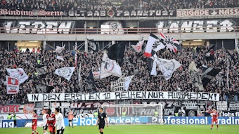 Die Fans von Eintracht Frankfurt halten im Stadion ein Banner hoch.