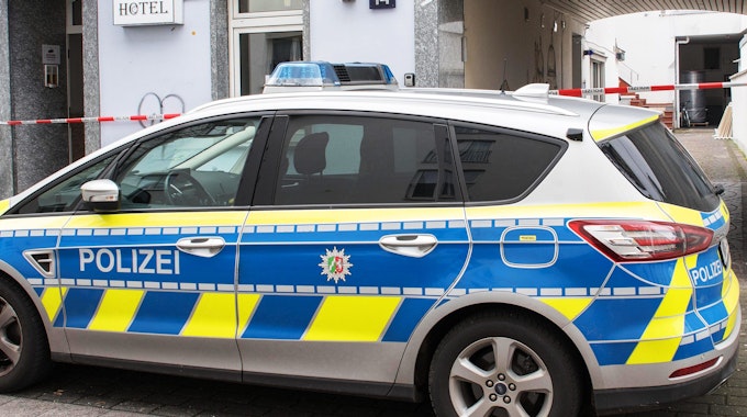 Ein Polizeiauto steht vor dem Hotel in Köln-Kalk, in dem am Samstag (11. März 2023) zwei schwer verletzte Männer gefunden wurden. Beide kamen mit Schnittverletzungen in Krankenhäuser.