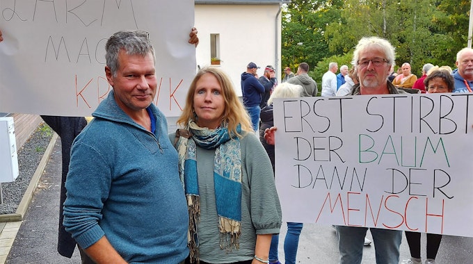 Einige Menschen protestieren mit Plakaten gegen den Bau eines Feriendorfs am Freilinger See.