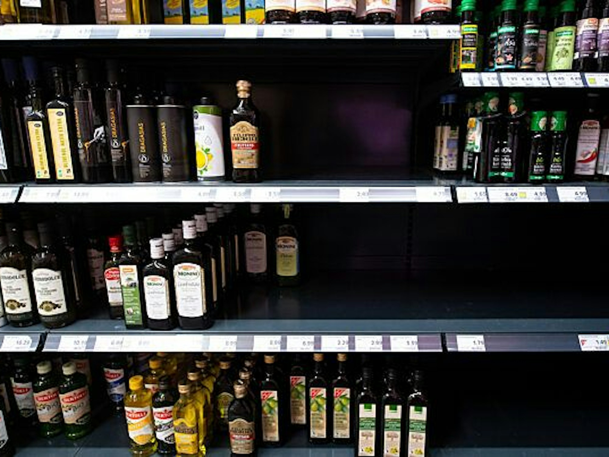 In einem Supermarktregal finden sich verschiedene Speiseöle, außer das Sonnenblumenöl, wieder.