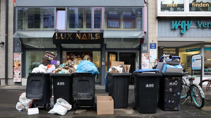 Ungeleerte Mülltonnen und Müllreste in der Stadt.