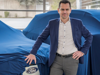 Martin Sander, Ford-Chef in Köln, steht neben einem E-Modell von Ford.