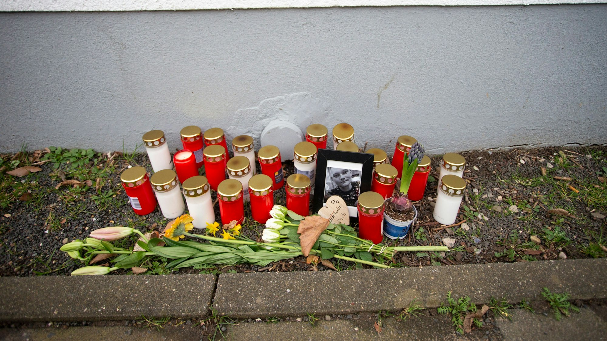Bekannte und Freunde des Opfers haben Kerzen und Blumen in der Nähe des Tatorts abgelegt. Ein 23-Jähriger ist am Sonntagabend nach Angriffen in Köln Stammheim tödlich verletzt worden. . © Thomas Banneyer