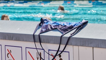 Ein Badeanzug liegt auf einer Mauer eines Schwimmbeckens