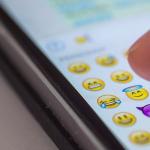 Das Symbolfoto aus dem Jahr 2015 zeigt einen Smartphone-Bildschirm, auf dem Emojis zu sehen sind. WhatsApp stellt bald wieder 21 neue Mini-Bildchen zur Verfügung.