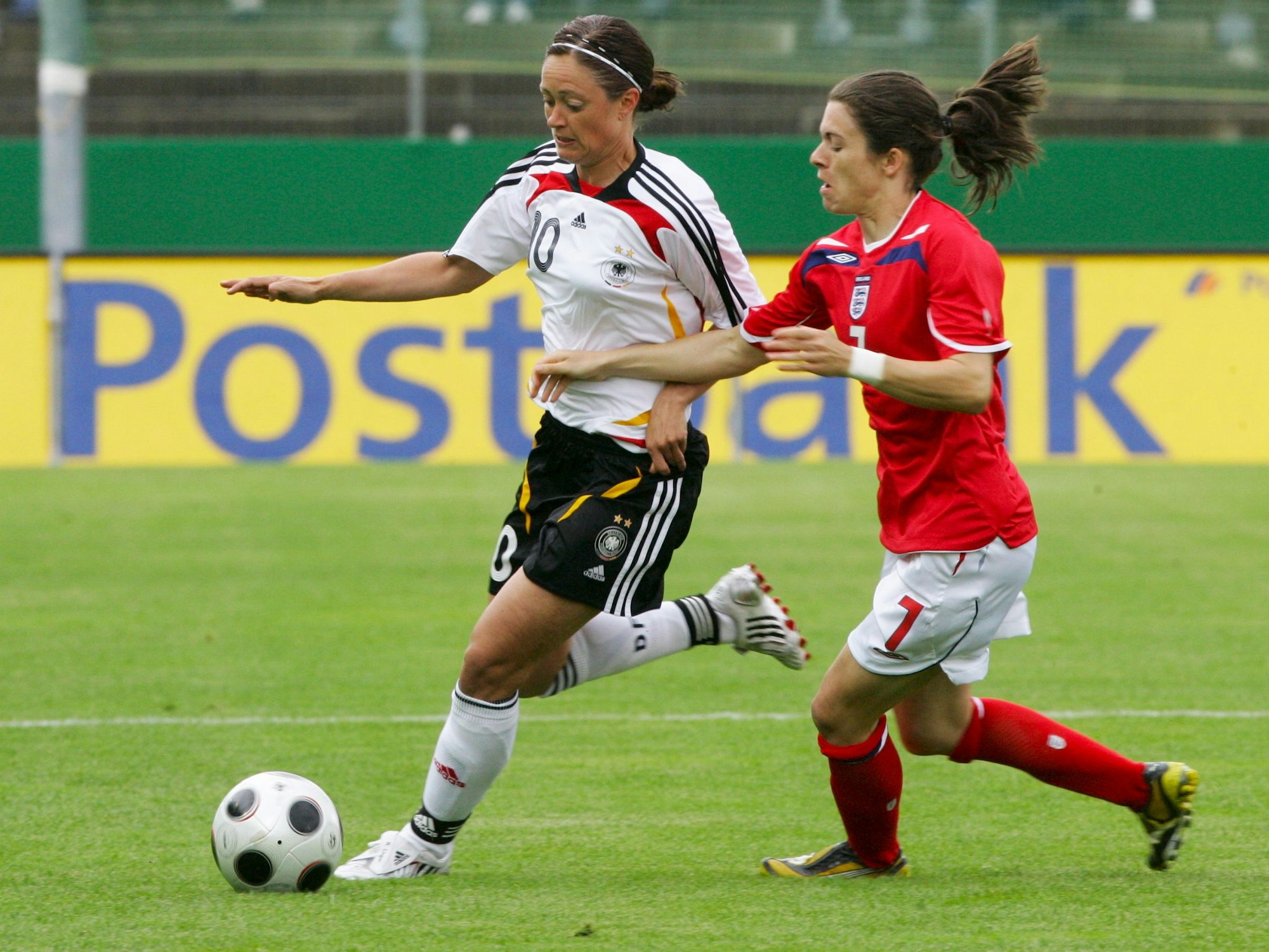 Die deutsche Mittelfeldspielerin Renate Lingor im Zweikampf mit der Engländerin Karen Carney.