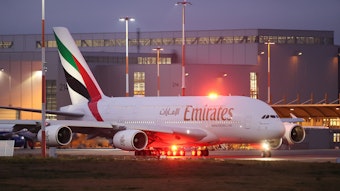 Ein Airbus A380 der arabischen Fluggesellschaft Emirates rollt zur Start- und Landebahn. Im Hintergrund ist ein großer Hangar zu sehen.