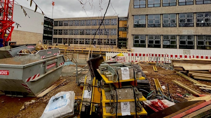 Blick auf die Baustelle des Schulzentrums. Ein Container und Schutt stehen vor dem Gebäude.