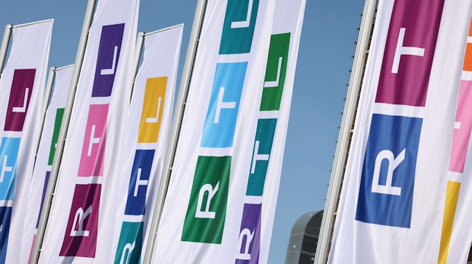 Fahnen mit dem Logo des Fernsehsenders RTL wehen vor dessen Gebäude.