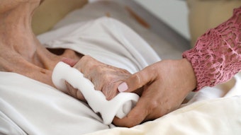 Eine Pflegeschwester hält die Hand einer alten Heimbewohnerin im Altenzentrum Luisenhaus.