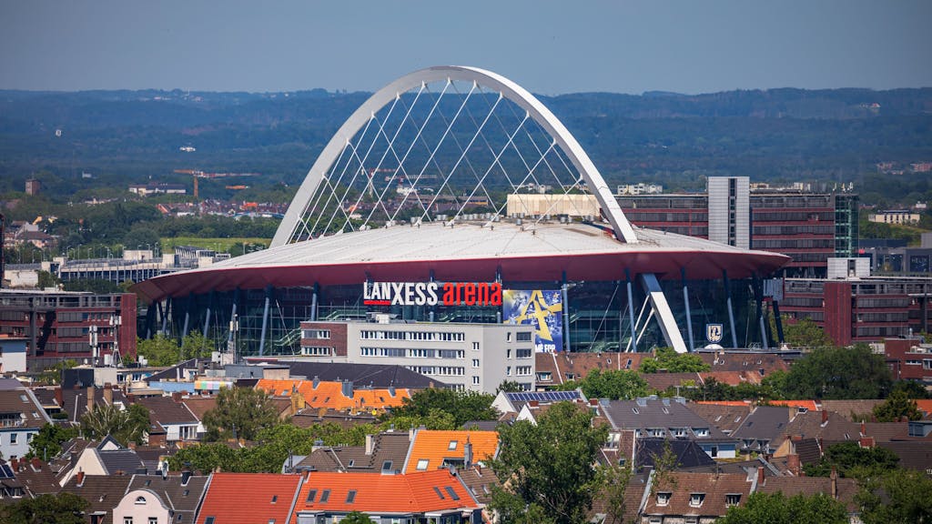 Die Lanxess Arena in Köln inmitten von Häusern.