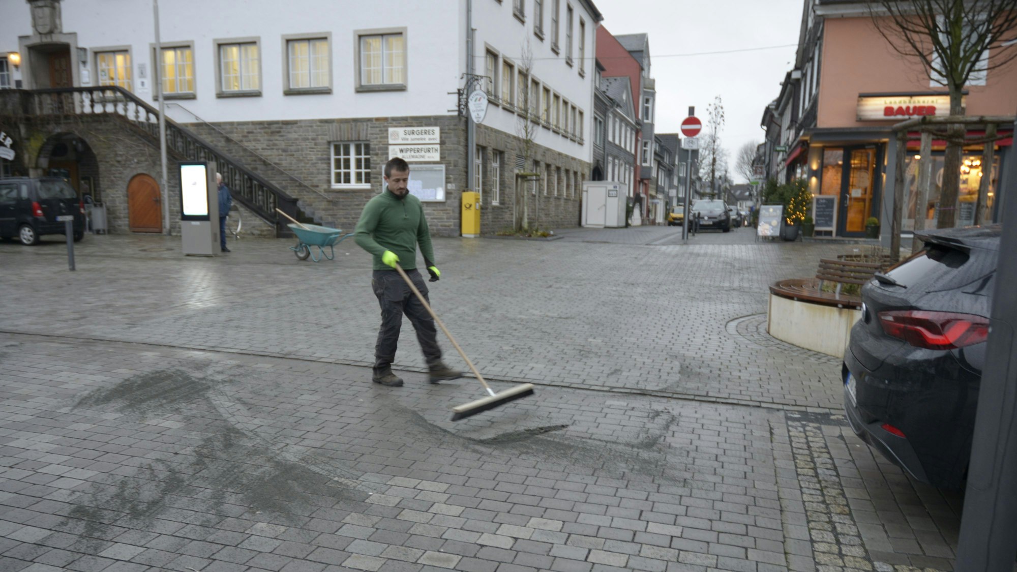 Ein Mitarbeiter der Firma G.W.D. verfugt die Grauwackesteine auf dem Marktplatz neu.