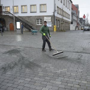 Ein Mitarbeiter der Firma G.W.D. verfugt die Grauwackesteine auf dem Marktplatz neu.