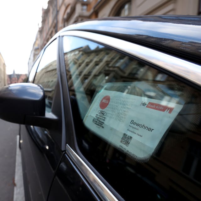 In einem Autofenster hängt ein Anwohnerparkausweis für das Belgische Viertel in Köln
