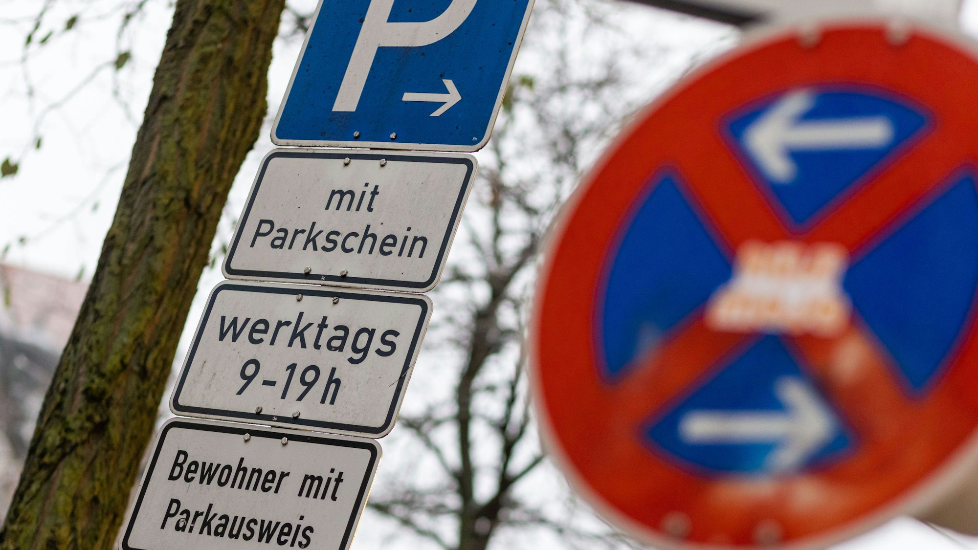 Schilder mit der Aufschrift «Parken», «mit Parkschein», «werktags 9-19 h», «Bewohner mit Parkausweis» stehen hinter einem Schild, das auf ein absolutes Halteverbot hinweist.