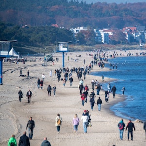 Menschen spazieren am Strand der Insel Usedom. Das Foto in Heringsdorf wurde im Oktober 2021 aufgenommen.