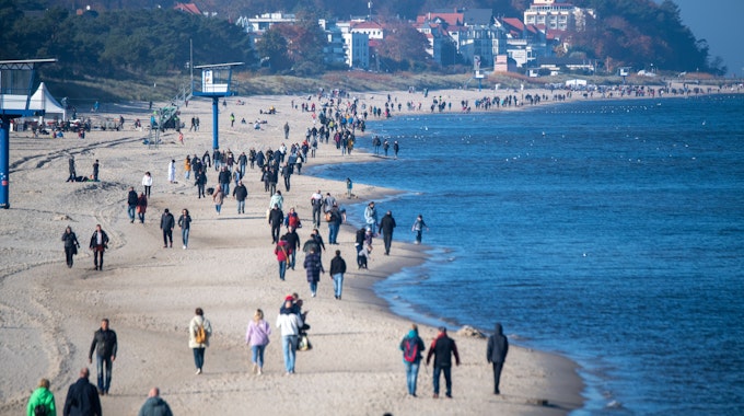 Menschen spazieren am Strand der Insel Usedom. Das Foto in Heringsdorf wurde im Oktober 2021 aufgenommen.