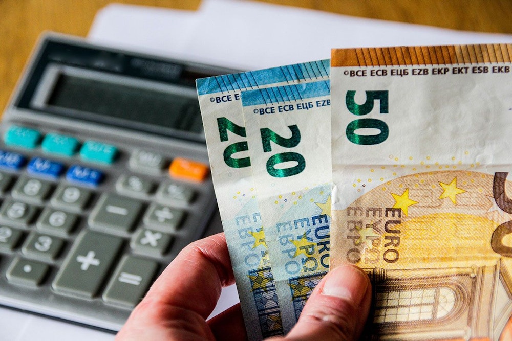 Taschenrechner und Euro-Scheine in einer Hand